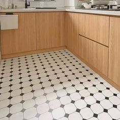 a kitchen with wooden cabinets and black and white tile flooring on the counter top