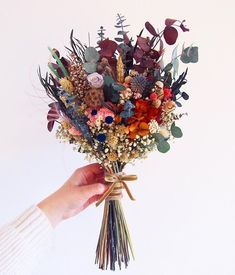 a person holding a bouquet of flowers in their hand