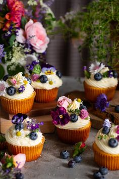 cupcakes with white frosting and fresh flowers on top