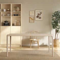 a white table and chairs in a room with beige walls, rugs and pictures on the wall