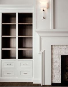 a white bookcase in front of a fireplace