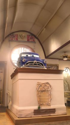 a car is on display in a museum with other cars and artifacts around the room