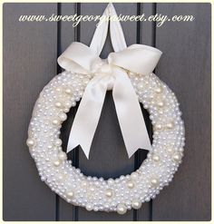 a white wreath with pearls and a bow