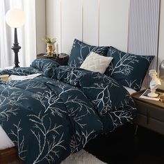 a bed with blue and white comforters in a bedroom next to a window,