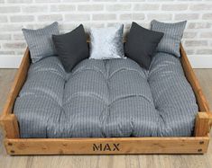 a couch made out of wood with pillows on it and the word max written in black