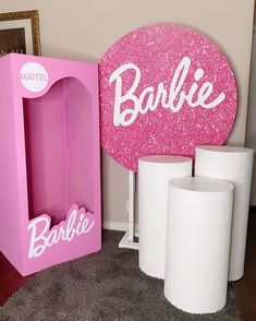 there is a barbie sign next to two vases and a pink box with the word barbie on it