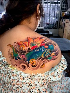 a woman with a colorful tattoo on her shoulder