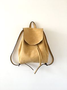 "This bag is made of high quality vegan leather in yellow. It is very soft and lightweight but durable. It has a rustic, distressed look. It has one interior and one exterior zipper pocket. Straps are adjustable. It is suitable for both men and women. Small : 17 x 27 x 30 cm Large : 20 x 30 x 36 cm IMPORTANT! Your orders between 7-25 August will be shipped on August 28. Delivery takes 2-5 days to the US, Canada, Australia and Europe; in 3-7 days to rest of the world after shipping. For other col Beige Softback Leather Backpack For Daily Use, Yellow Leather Travel Backpack With Adjustable Strap, Yellow Leather Rectangular Backpack, Yellow Rectangular Leather Backpack, Everyday Yellow Backpack With Removable Pouch, Yellow Leather Backpack With Adjustable Strap For Daily Use, Beige Leather Softback Backpack, Yellow Satchel Backpack For Daily Use, Yellow Backpack For Everyday Use