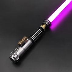 a purple light saber is shown on a black surface with a gold trimming around it