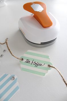 an orange and white stapler sitting on top of a table next to a tag