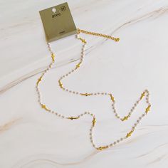 This Pearls And Crosses Long Necklace features a beautiful mix of tiny golden crosses and pearl bead chain. Its design allows for versatile styling options, such as doubling up the 32-inch chain for a choker effect, or wearing it long over a shirt or sweater. Its dainty details are sure to add a sophisticated finishing touch to any outfit. 32" long with a 2" extender Gold plated brass, acrylic pearl beads Lead and Nickel compliant Made in China Gold Cross Necklace With Pearl Chain, Gold Pearl Chain Cross Necklace, Hair Setting, Double Up, Bead Chain, Blanket Scarf, Scrunchie Hairstyles, Hair Accessories Headbands, Stainless Steel Jewelry