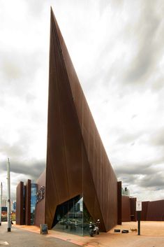 a large triangular shaped building sitting on the side of a road