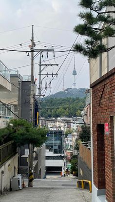 an alley way with power lines above it and buildings on the other side in the distance