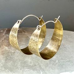 These sweet, wide brass hoops make great "every day" earrings. Hammered and oxidized, sterling ear wire fits into hole in back of hoop to close. Small - around 3/4" diameter Medium - 1 1/2" diameter Large - a little over 2" diameter Everyday Metal Hoop Earrings With Oxidized Finish, Everyday Hand Forged Bronze Earrings, Artisan Oxidized Hoop Earrings, Artisan Hoop Earrings With Oxidized Finish, Hand Forged Brass Circle Earrings, Bronze Brass Hoop Earrings With Ear Wire, Bronze Ear Wire Hoop Earrings In Brass, Bohemian Hand Forged Hoop Earrings For Everyday, Everyday Handmade Metal Hoop Earrings