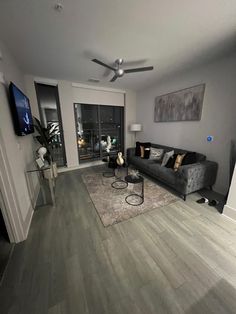 a living room filled with furniture and a flat screen tv mounted to the side of a wall