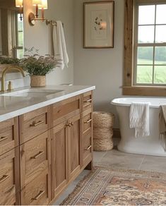 a bath room with a tub a sink and a window