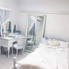 a bedroom with a bed, desk and mirror