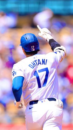 the baseball player is getting ready to hit the ball with one hand and holding his glove out