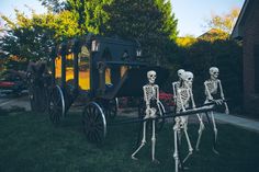 three skeletons are standing in front of a horse drawn carriage