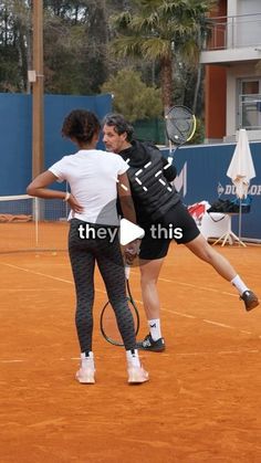 two people playing tennis on an orange court