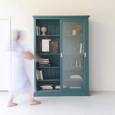 a blurry image of a person walking past a bookcase