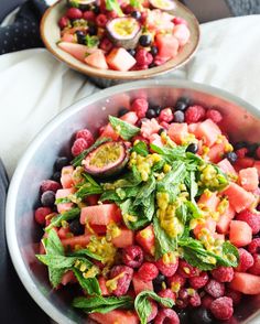 two bowls filled with fruit and veggies on top of a table