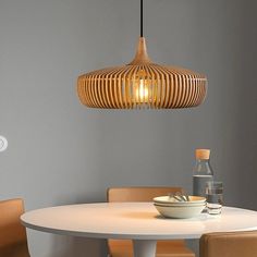 a white table and chairs with a light fixture above it that is hanging from the ceiling