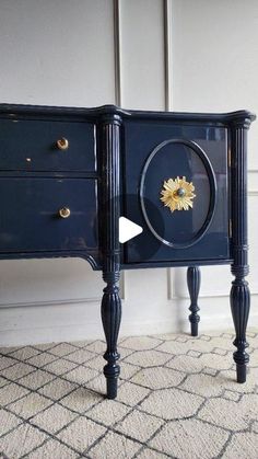 a blue dresser with gold flowers on the top and bottom drawers, sitting in a room