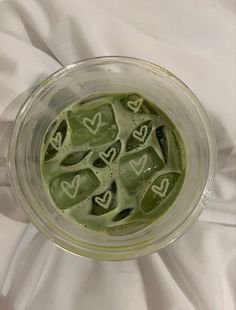 a blender filled with green liquid on top of a white sheet covered tablecloth