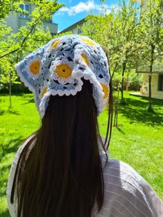 the back of a woman's head wearing a crocheted sunflower hat