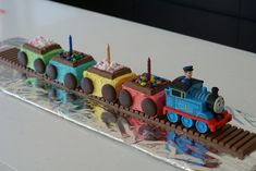 a cake shaped like a train is sitting on a table with frosting and decorations