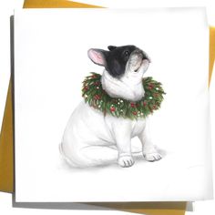 a white and black dog wearing a christmas wreath