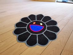 a black and blue flower rug sitting on top of a wooden floor