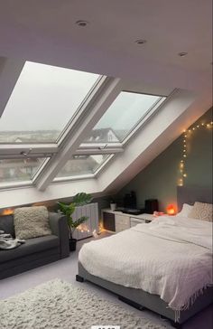 an attic bedroom with skylights and a bed in the corner, along with two couches