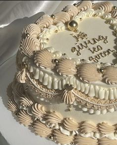 a three layer cake decorated with seashells and pearls