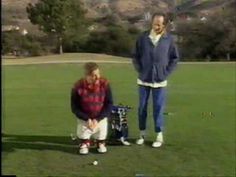 two men standing on top of a lush green field next to a golf ball marker