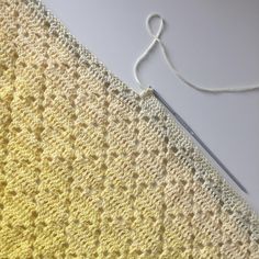 a crocheted piece of cloth next to a pair of scissors