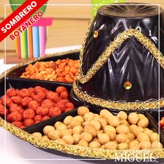 a tray filled with lots of different types of nuts next to a black hat on top of it