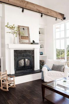 a living room with white furniture and a fireplace