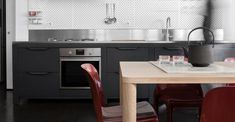 the kitchen is clean and ready to be used for cooking or dining, with red chairs around the table