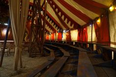 the inside of a circus tent with benches and lights