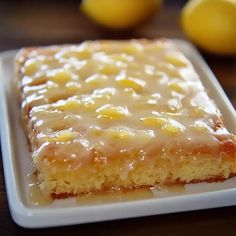 a close up of a cake on a plate with lemons in the background