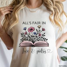 All's Fair In Love & Poetry Shirt, Love and Poetry T-shirt, Book with Flowers, Taylor Fan Shirt, Music Lover Shirt, Gift for Daughter Mom This classic unisex jersey short sleeve tee fits like a well-loved favorite. Soft cotton and quality print make users fall in love with it over and over again. These t-shirts have-ribbed knit collars to bolster shaping. The shoulders are tapered for a better fit over time. Dual side seams hold the garment's shape for longer.  .: Made with 100% Airlume combed a Bookish Short Sleeve T-shirt For Spring, Spring Bookish Short Sleeve T-shirt, Spring Bookish Style Short Sleeve T-shirt, Spring Bookish T-shirt With Letter Print, Summer Bookish Tops With Letter Print, Bookish Style Letter Print Summer Tops, Spring Cotton T-shirt With Bookish Style, Spring Bookish Short Sleeve Tops, Bookish Short Sleeve Tops For Spring