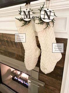 two christmas stockings hanging from the fireplace mantel with monogrammed letters on them