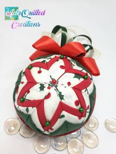 a christmas ornament with red and green bows on it, surrounded by buttons