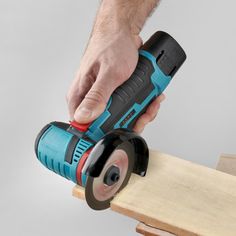 a man is using a cordless sander on a piece of wood