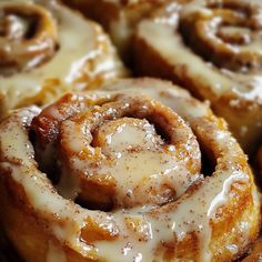 several cinnamon rolls with icing on top of each one sitting in a pile, ready to be eaten