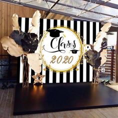 a stage set up with black and white striped backdrop, gold foil stars and graduation decorations