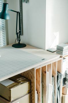 a desk with some boxes and a lamp on it