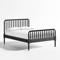 a black bed frame with white sheets and pillows